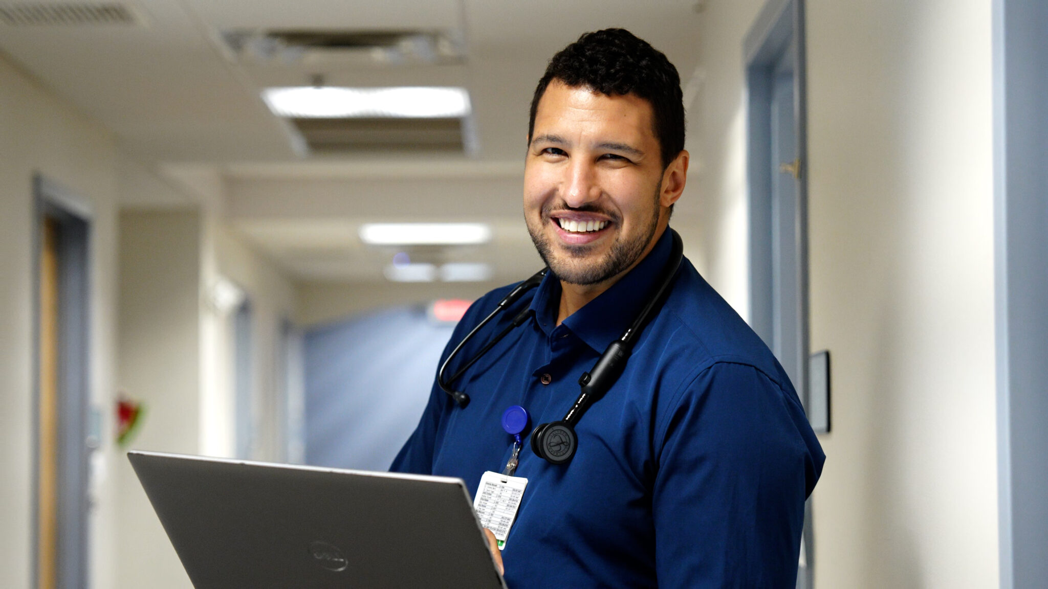 nurse using a computer smiling.